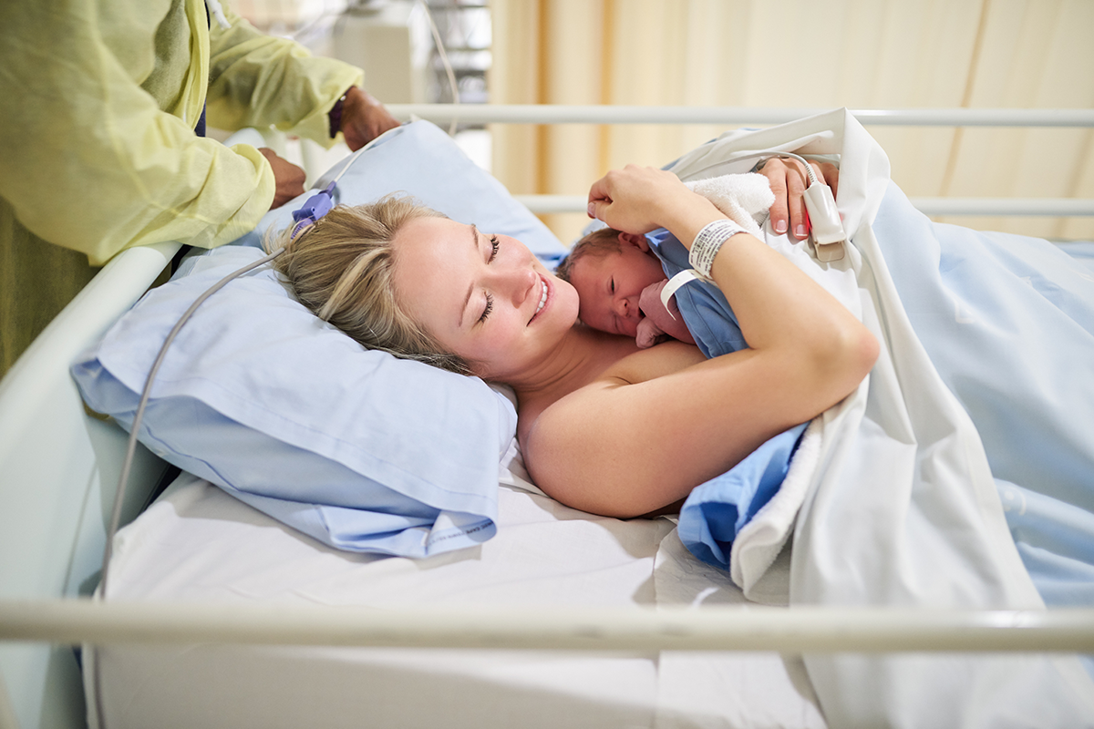 motherhood and woman with newborn healthcare or love for baby on bed